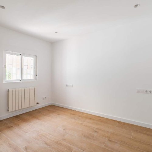 empty-room-after-renovation-with-window-white-walls-and-wooden-floor-in-new-apartment